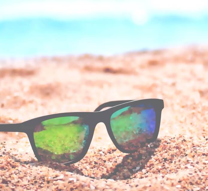 black-rimmed polarized sunglasses on a beach